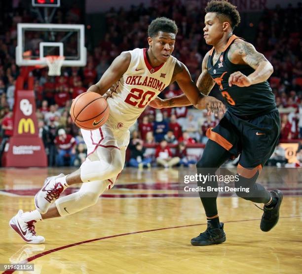 Kameron McGusty of the Oklahoma Sooners drives inside as Jacob Young of the Texas Longhorns defends at Lloyd Noble Center on February 17, 2018 in...