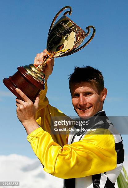 Brad Rawiller celebrates with the trophy after riding Viewed in the Caulfield Cup during the Caulfield Cup Day meeting at Caulfield Racecourse on...