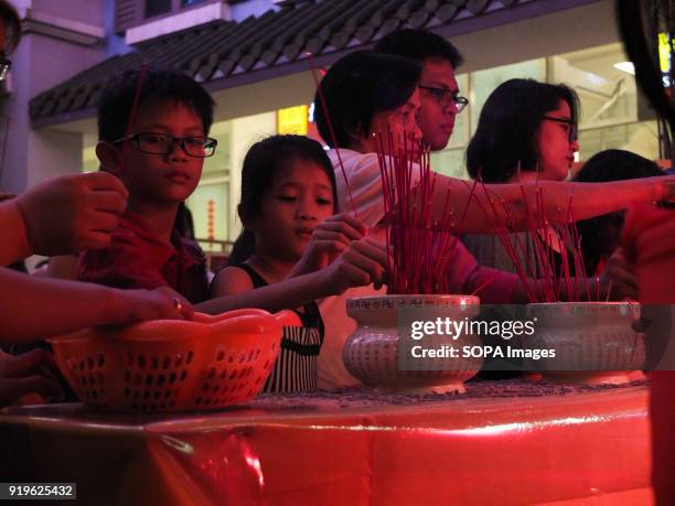 Child lighting an insense with family during the chinese new year celebration. Filipinos celebrated the Chinese New year by visiting chinatown in...