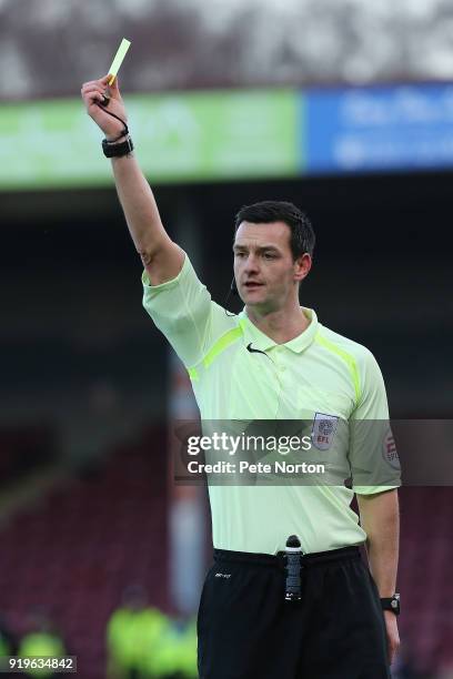 Referee Andrew Madley shows a yellow card during the Sky Bet League One match between Scunthorpe United and Northampton Town at Glanford Park on...