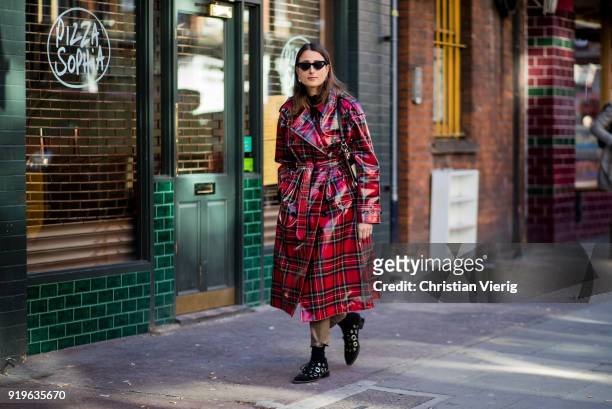 Julia Haghjoo wearing red black plaid Burberry coat seen outside J.W. Anderson during London Fashion Week February 2018 on February 17, 2018 in...