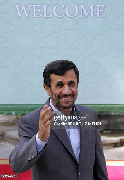 Iranian President Mahmoud Ahmadinejad waves to reporters as he waits for his Senegalese counterpart Abdoulaye Wade at the presidential offices in...