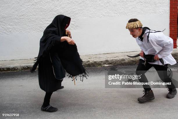 Reveller dressed as an old lady brings the attention of the Vaquilla 'heifer' during the traditional Navalacruz Carnival on February 17, 2018 in...