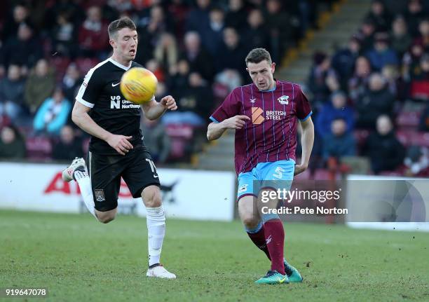 Murray Wallace of Scunthorpe United plays the ball past Chris Long of Northampton Town during the Sky Bet League One match between Scunthorpe United...