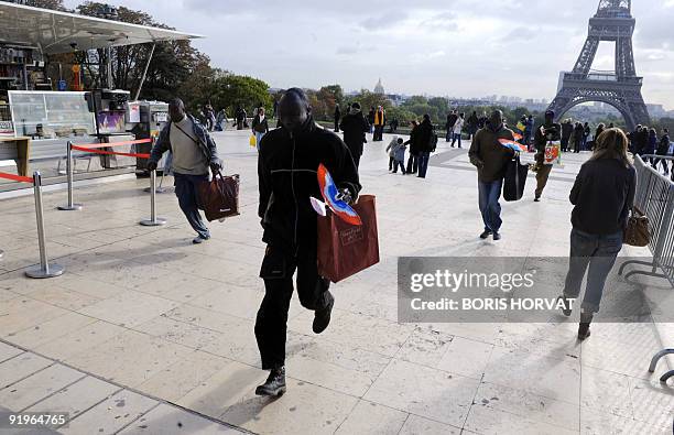 Illegal street salesmen run away to escape from a police patrol as they were selling souvenirs, on the Esplanade du Trocadero, in front of the Eiffel...