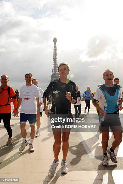 French athlete Serge Girard runs on the Esplanade du Trocadero, in front of the Eiffel tour after the start of his solo race in Paris, on October 17...