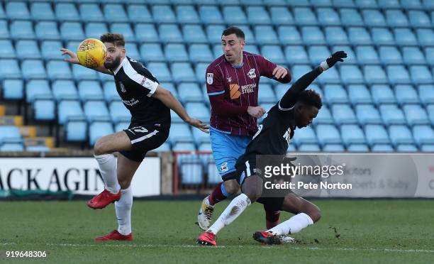 Lee Novak of Scunthorpe United contests the ball with Jordan Turnbull and Gboly Ariyibi of Northampton Town during the Sky Bet League One match...