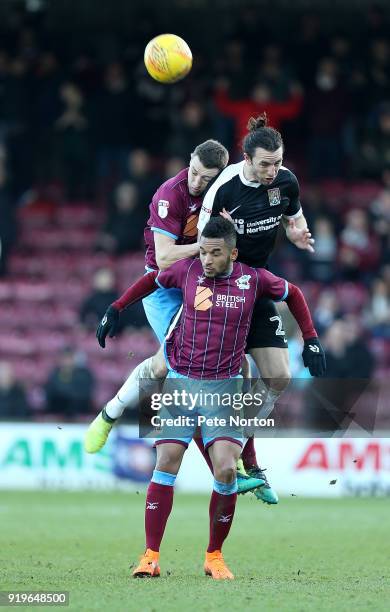 Funso Ojo and Murray Wallace of Scunthorpe United contest the ball with John-Joe O'Toole of Northampton Town during the Sky Bet League One match...
