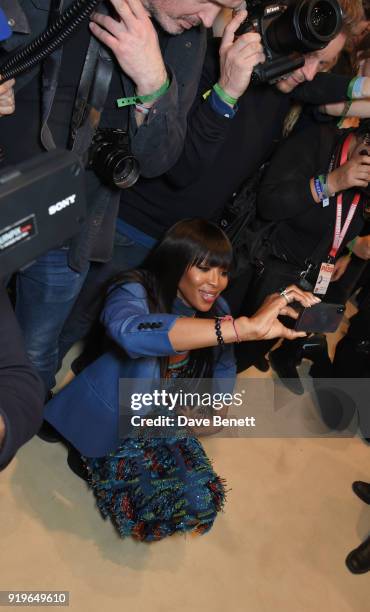 Naomi Campbell wearing Burberry takes photos backstage at the Burberry February 2018 show during London Fashion Week at Dimco Buildings on February...