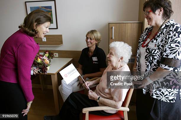 Queen Silvia of Sweden talks to inpatient Margarete Weier during the opening of the first german section in a hospital for dementia patients...