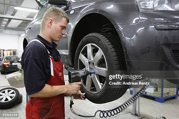 Mechanician changes a tire at a Audi garage on October 17, 2009 in Berlin, Germany. German's prepare their cars for winter as cold temperatures and...