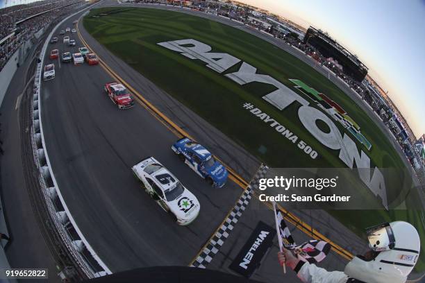 Tyler Reddick, driver of the BurgerFi Chevrolet, takes the checkered flag in front of Elliott Sadler, driver of the OneMain Financial Chevrolet, to...