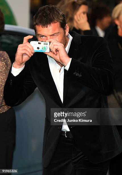 Actor Sam Worthington takes pictures of the press on the green carpet during the 22nd Tokyo International Film Festival Opening Ceremony at Roppongi...