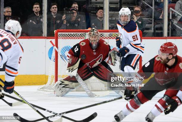 Goalie Antti Raanta of the Arizona Coyotes looks to make a save on the shot by Anton Slepyshev of the Edmonton Oilers as Drake Caggiula of the Oilers...