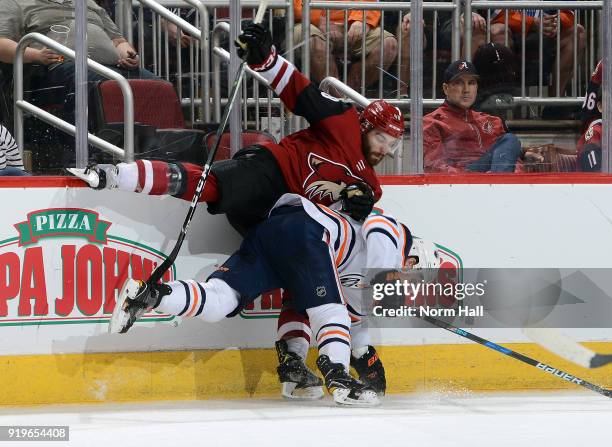 Jordan Martinook of the Arizona Coyotes checks Kris Russell of the Edmonton Oilers along the boards during the second period at Gila River Arena on...