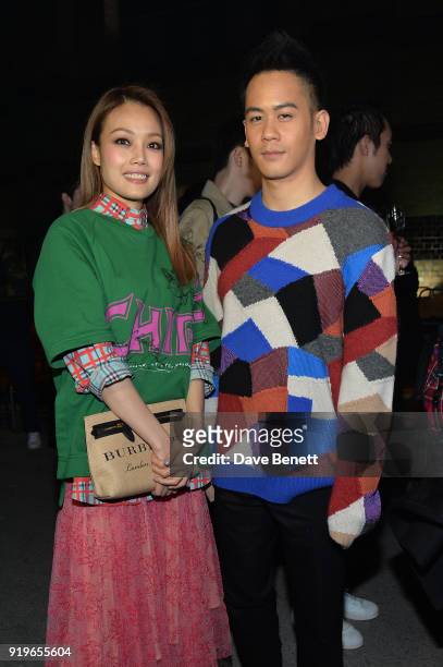 Joey Yung and Mason Lee wearing Burberry at the Burberry February 2018 show during London Fashion Week at Dimco Buildings on February 17, 2018 in...