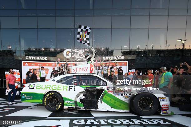 Tyler Reddick, driver of the BurgerFi Chevrolet, celebrates in Victory Lane after winning the NASCAR Xfinity Series PowerShares QQQ 300 at Daytona...