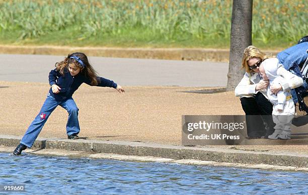 Singer Madonna embraces her son Rocco, while her daughter, Lourdes, plays in the water during an outing in Hyde Park April 21, 2002 in London,...