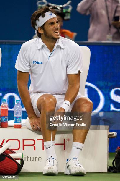 Feliciano Lopez of Spain examines his foot before retiring against his compatriot Rafal Nadal on their semi final match during day seven of 2009...