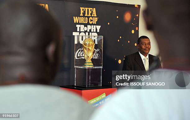 Man poses with the 2010 World Cup trophy on October 17, 2009 at the palais de la Culture in Abidjan as the trophy makes a regional tour. Ivory Coast...