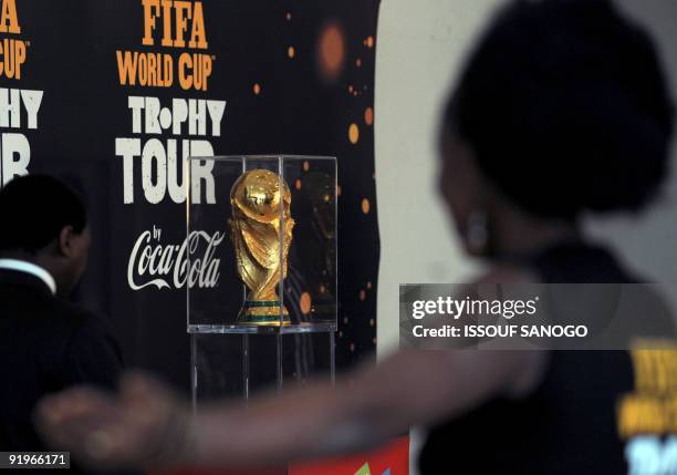 Man poses with the 2010 World Cup trophy on October 17, 2009 at the palais de la Culture in Abidjan as the trophy makes a regional tour. Ivory Coast...