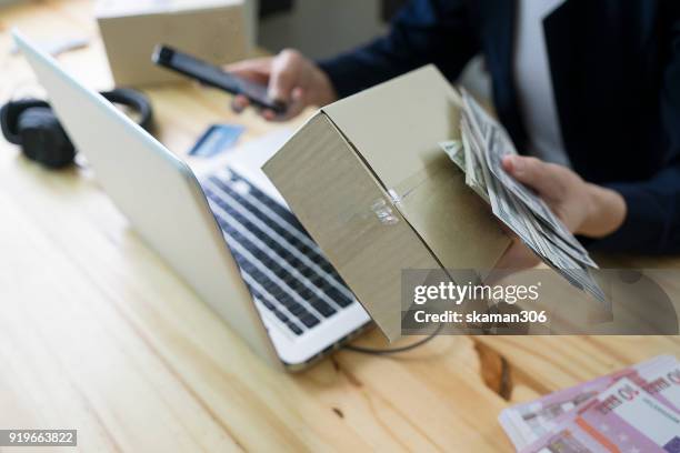 asian business man holding tablet for online shopping with laptop computer and with packaged to be shipped global - quitar fondo de imagen online fotografías e imágenes de stock