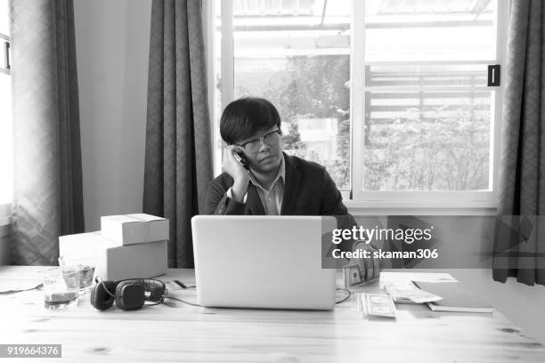 asian business man holding tablet for online shopping with laptop computer and with packaged to be shipped global - quitar fondo de imagen online fotografías e imágenes de stock