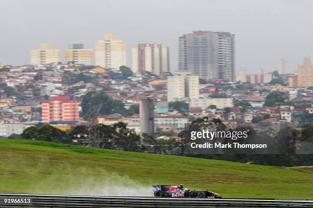 Sebastien Buemi of Switzerland and Scuderia Toro Rosso drives in the rain affected final practice session prior to qualifying for the Brazilian...