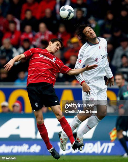 Luca Toni of Muenchen jumps for a header with Johannes Flum of Freiburg during the Bundesliga match between SC Freiburg and Bayern Muenchen at the...
