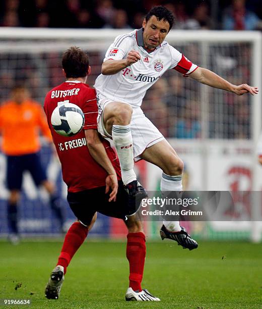 Mark van Bommel of Muenchen is challenged by Heiko Butscher of Freiburg during the Bundesliga match between SC Freiburg and Bayern Muenchen at the...