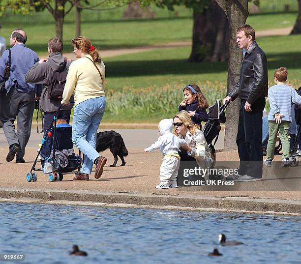 Singer Madonna plays with her son, Rocco, while her husband, producer Guy Ritchie and daughter, Lourdes, stand behind them during a walk in Hyde Park...