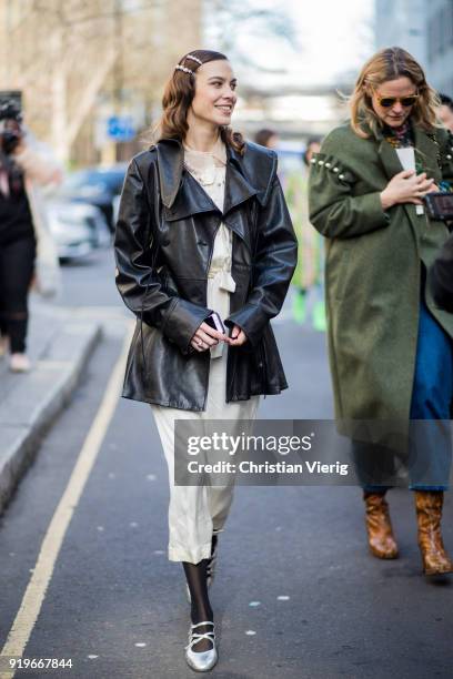 Alexa Chung wearing dress, black leather coat seen outside Simone Rocha during London Fashion Week February 2018 on February 17, 2018 in London,...