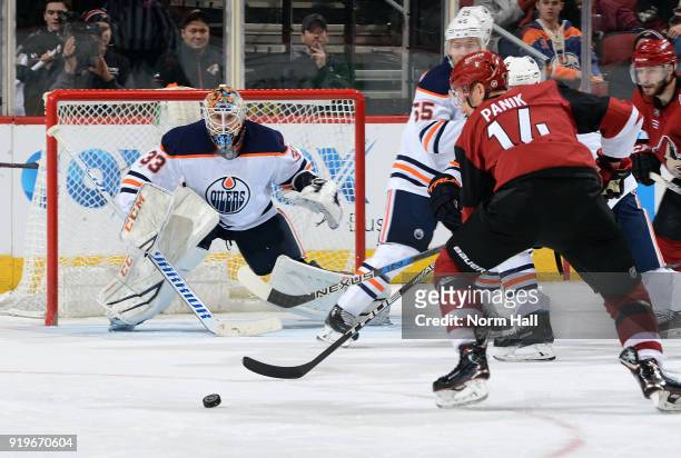 Goalie Cam Talbot of the Edmonton Oilers positions himself for a save as Richard Panik of the Arizona Coyotes prepares to shoot the puck during the...