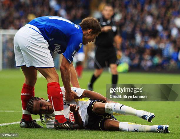 Michael Brown of Portsmouth tries to help Benoit Assou Ekotto of Tottenham Hotspur to his feet during the Barclays Premier League match between...