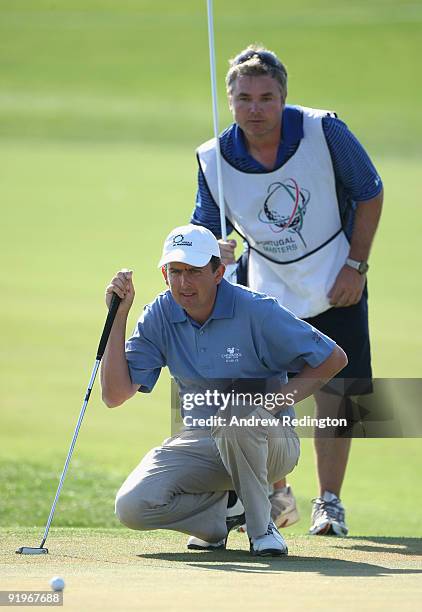 Peter Lawrie of Ireland and his caddie line up a putt on the 17th hole during the third round of the Portugal Masters at the Oceanico Victoria Golf...