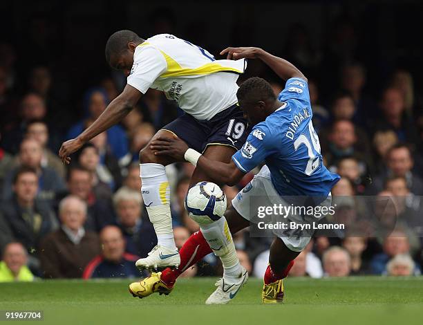 Sebastien Bassong of Tottenham Hotspur is tackled by Aruna Dindane of Portsmouth during the Barclays Premier League match between Portsmouth and...