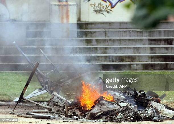 The remains of a police helicopter shot down by drug dealers still burn at Morro dos Macacos shantytown in Rio de Janeiro, Brazil October 17, 2009....