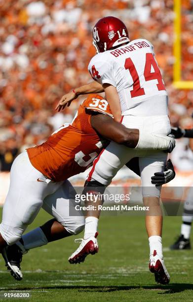 Quarterback Sam Bradford of the Oklahoma Sooners is tackled by Lamarr Houston of the Texas Longhorns at Cotton Bowl on October 17, 2009 in Dallas,...