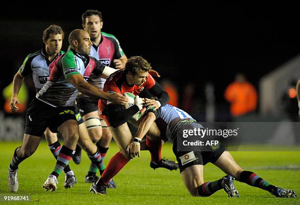 Vincent Clerc from Toulouse is tackled by Tosh Mason and Gonzalo Tiesi of Harlequins at the Twickenham Stoop in London, on October 17 during a...