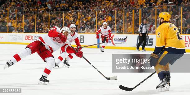 Trevor Daley of the Detroit Red Wings shoots the puck against Anthony Bitetto of the Nashville Predators during an NHL game at Bridgestone Arena on...