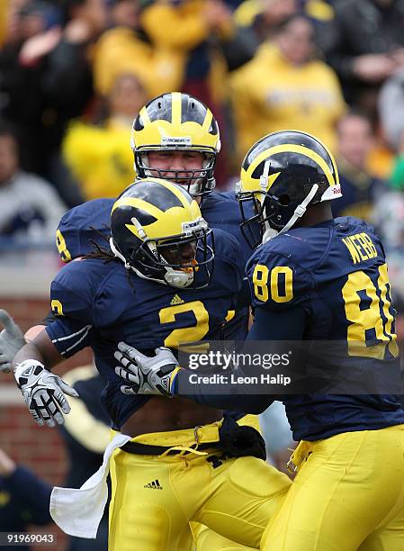 Vincent Smith of the Michigan Wolverines is congratulated by Martell Webb after running for a touchdown in the first quarter against the Delaware...