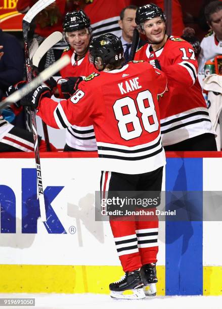 Patrick Kane of the Chicago Blackhawks is greeted by Patrick Sharp and Lance Bouma after scoring a second period goal against the Washington Capitals...