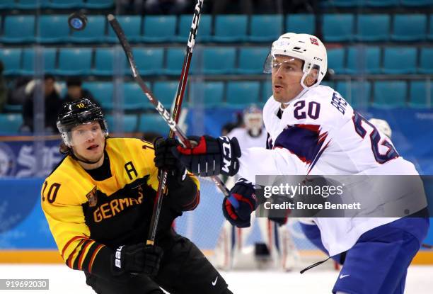 Christian Ehrhoff of Germany and Anders Bastiansen of Norway compete for a loose puck in the first period during the Men's Ice Hockey Preliminary...