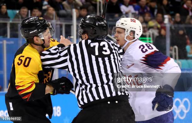 Patrick Hager of Germany and Niklas Roest of Norway are separated by a referee in the second period during the Men's Ice Hockey Preliminary Round...