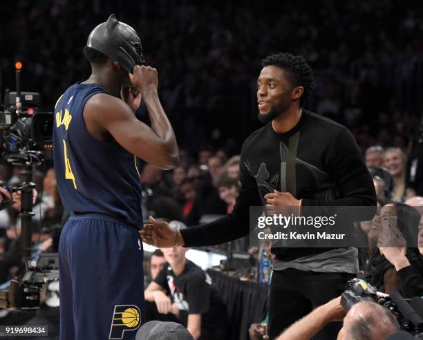 Player Victor Oladipo of the Indiana Pacers puts on Marvel's Black Panther mask from Chadwick Boseman during the 2018 State Farm All-Star Saturday...