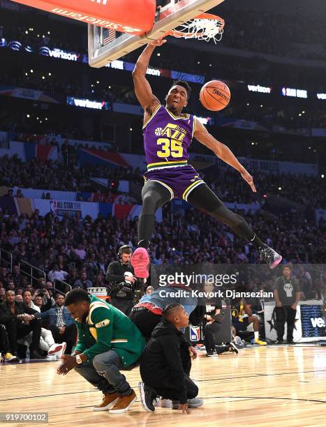 Donovan Mitchell of the Utah Jazz dunks over Kevin Hart, Jordan Mitchell and Hendrix Hart in the 2018 Verizon Slam Dunk Contest at Staples Center on...
