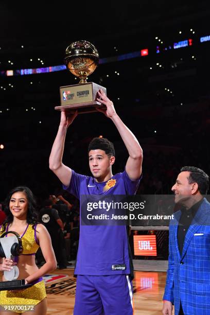 Devin Booker of the Phoenix Suns holds up the trophy after winning the three-point contest during the JBL Three-Point Contest during State Farm...