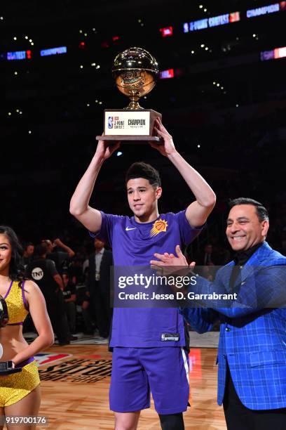 Devin Booker of the Phoenix Suns holds up the trophy after winning the three-point contest during the JBL Three-Point Contest during State Farm...