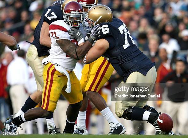 Running back Allen Bradford of the USC Trojans and guard Andrew Nuss of the Notre Dame Fighting Irish battles for the ball after a fumble on the...