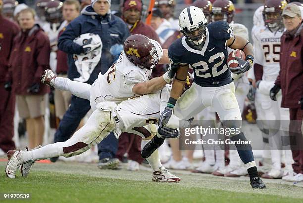 Evan Royster of the Penn State Nittany Lions is tackled by Kyle Theret and Marcus Sherels of the Minnesota Gophers at Beaver Stadium on October 17,...